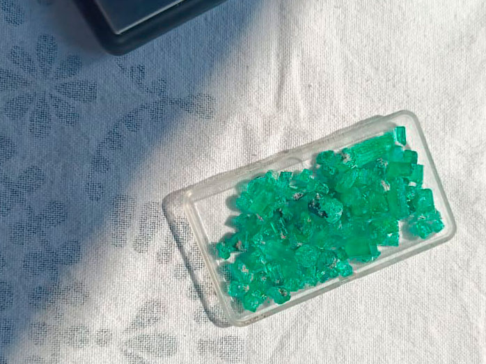 Colombian emeralds in a small plastic box