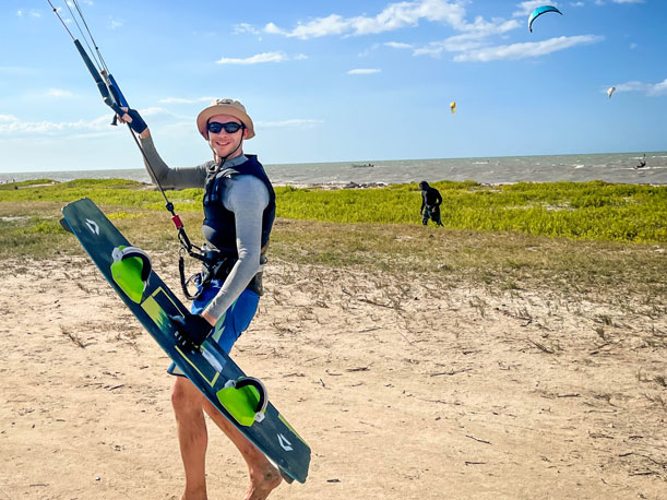 Man flying his kitesurf kite and carrying board during kite trip Colombia