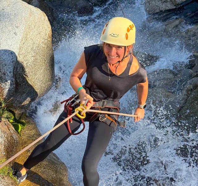 Woman rappelling down a waterfall canyoning Medellin