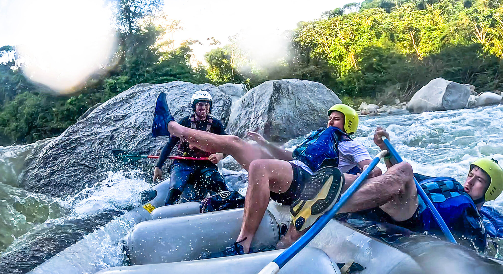 Two men falling out of a raft white water rafting Medellin
