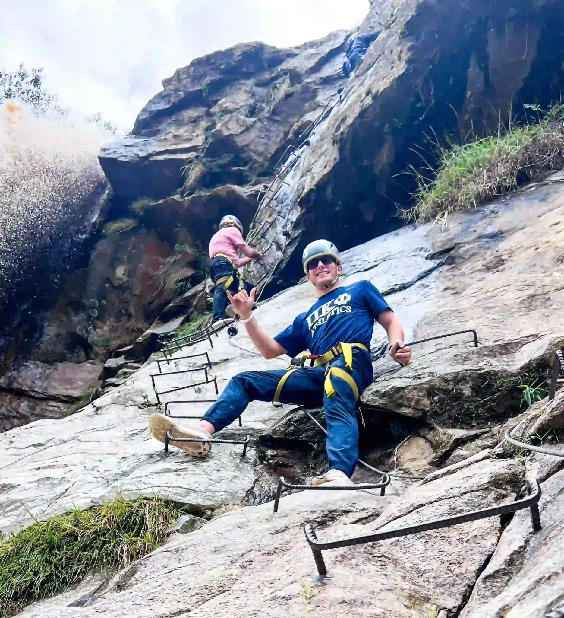 Young man climbing a rock face during zipline tours medellin