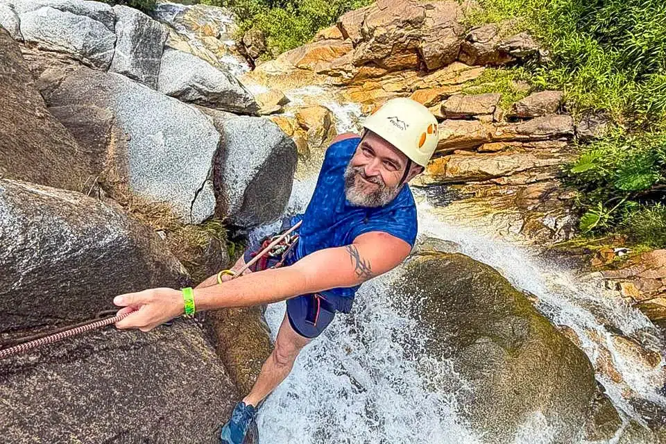 Man rappelling down a waterfall while canyoning in Medellin