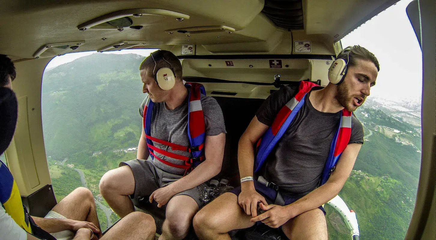 Two men in a helicopter tour over the lake of Guatape participating in unique things to do in Medellin