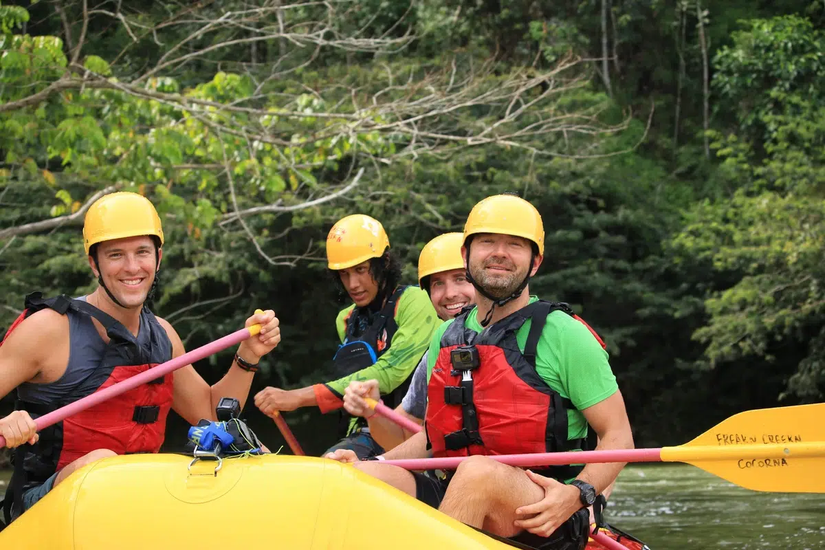 Two men smiling in a white water rafting while discovering unique things to do in Medellin