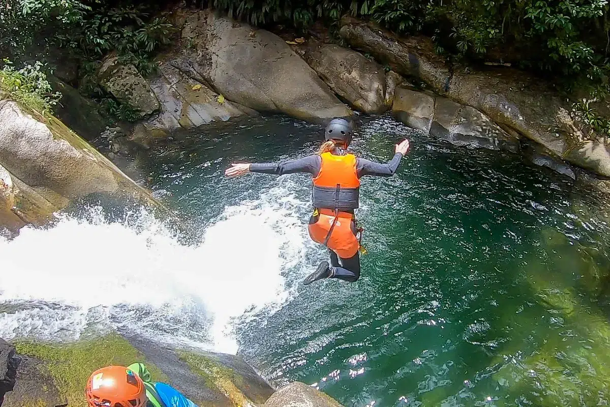 woman jumping into a natural pool while canyoning Medellin