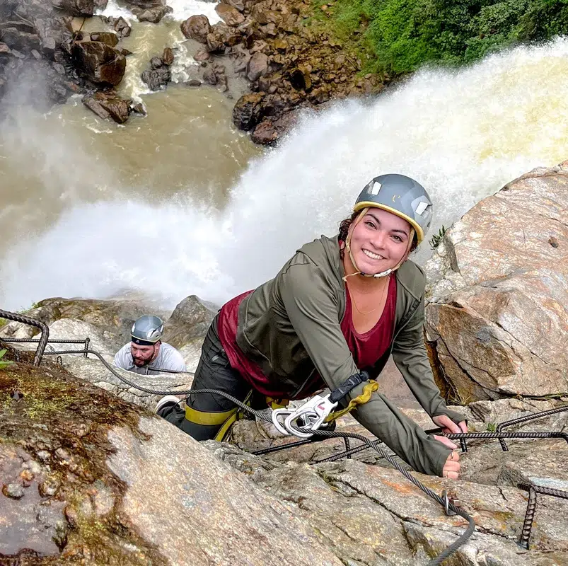 Woman climbig via ferrata waterfall Medellin tours