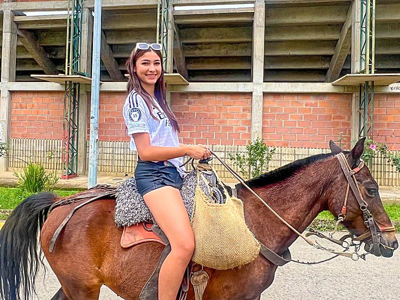 Girl riding horseback during coffee region tour from Medellin
